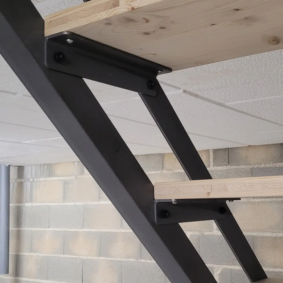 Supports de marche boulonnés aux limons (acier sablé + antirouille, épicéa 3 plis).